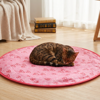 Round heart-print cat play pouch on a wood floor